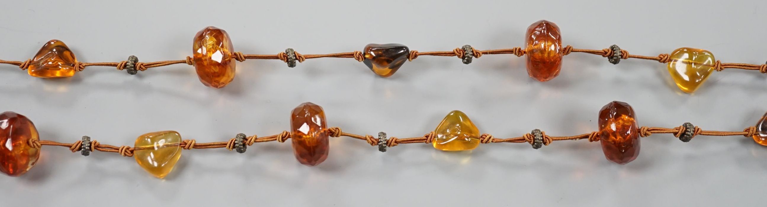 A single strand facetted and pebble amber necklace, 138cm.